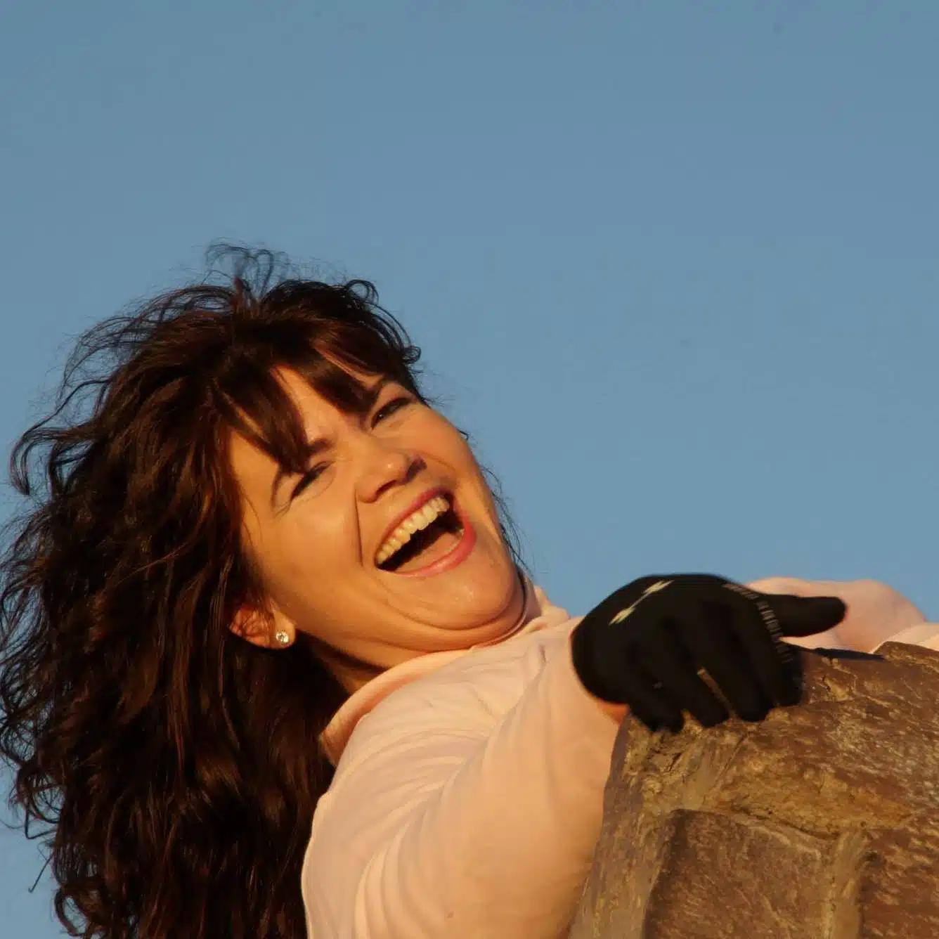 Dr.-Tricia-hiking-joy-min Picture of Dr. Tricia Groff hanging off of a rock and laughing